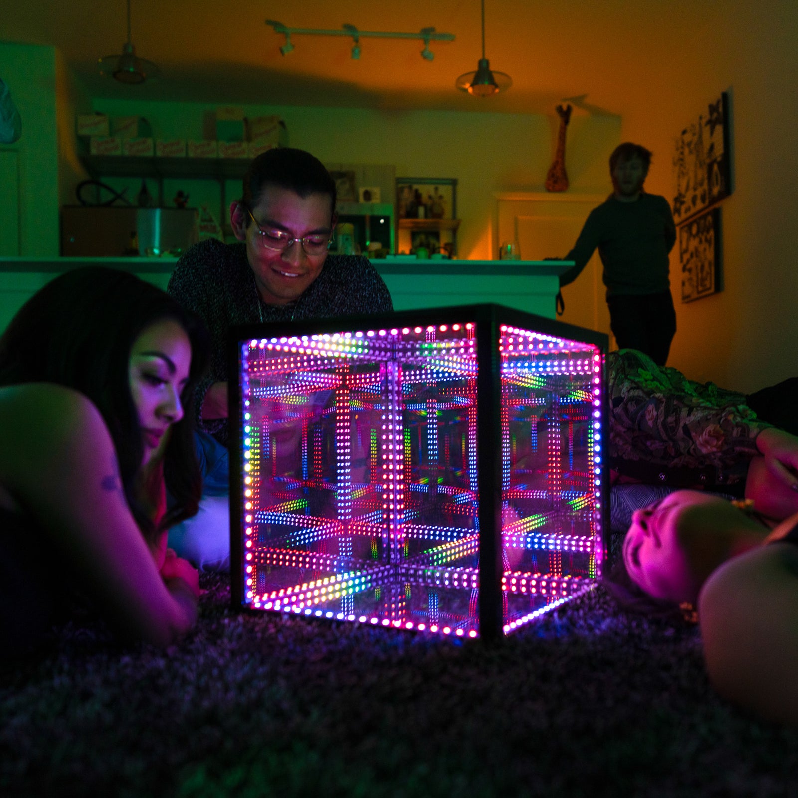 people on floor looking at hypercube