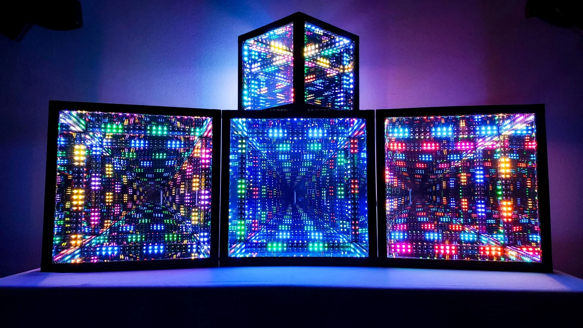 3 HyperCubes lined up together, with one stacked on top, creating an LED art installation