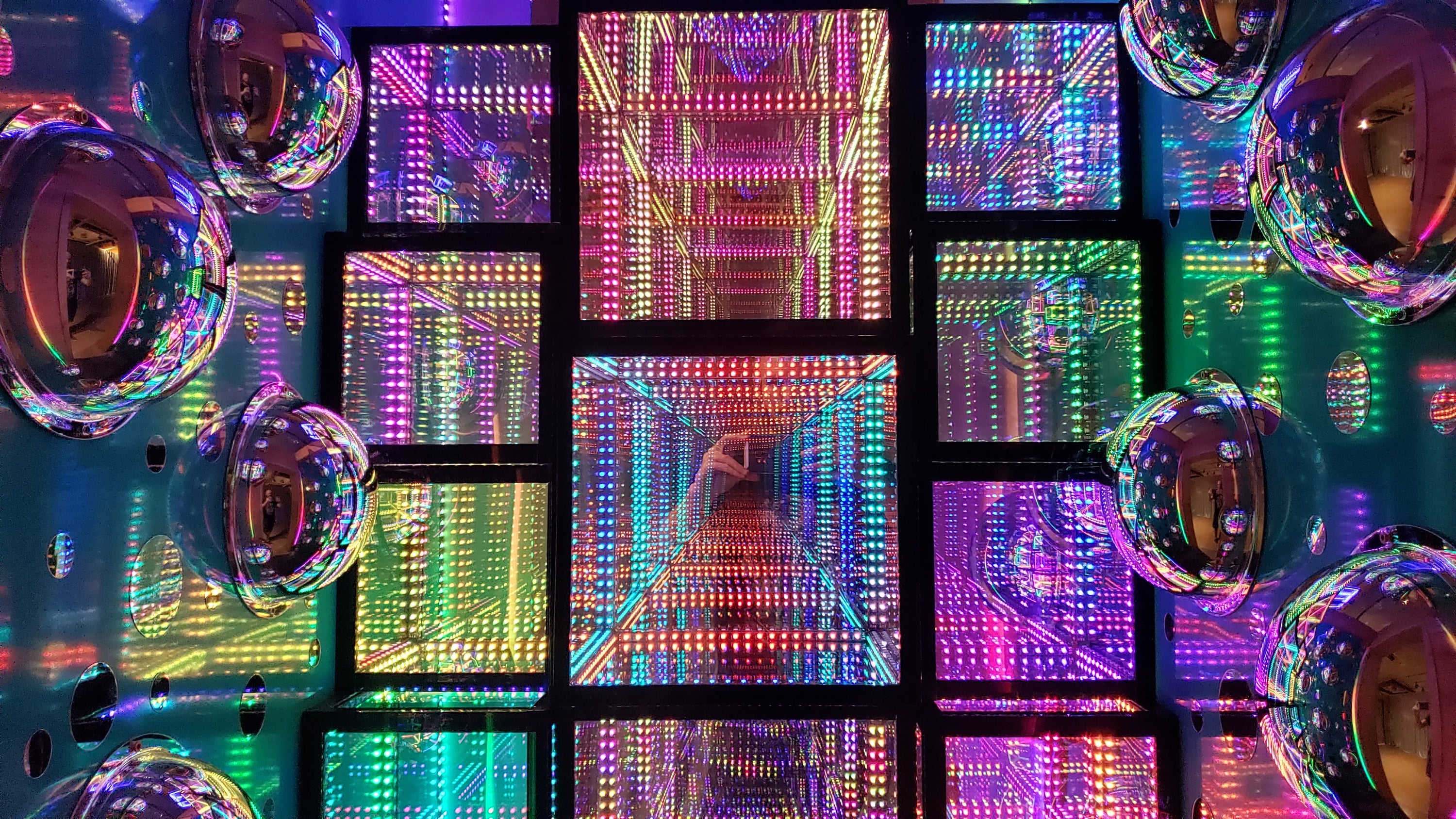 Multicolored Hypercubes with multicolored LED lights stacked upon each other, making a wall of cubes